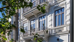Un edificio histórico con balcones ornamentales, ventanas amplias y un letrero que dice "HOLT 30th".