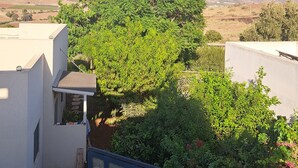 A residential area with a large tree in the center, surrounded by greenery and white buildings. - Mount Tabor Home by Sea N' Rent (Emek Izrael)