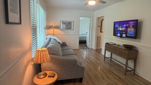 A living room with a sofa, a lamp, a television, and a ceiling fan. - Acre Inn- private countryside home south of Nashville, 15 min to Spring Hill (Spring Hill)