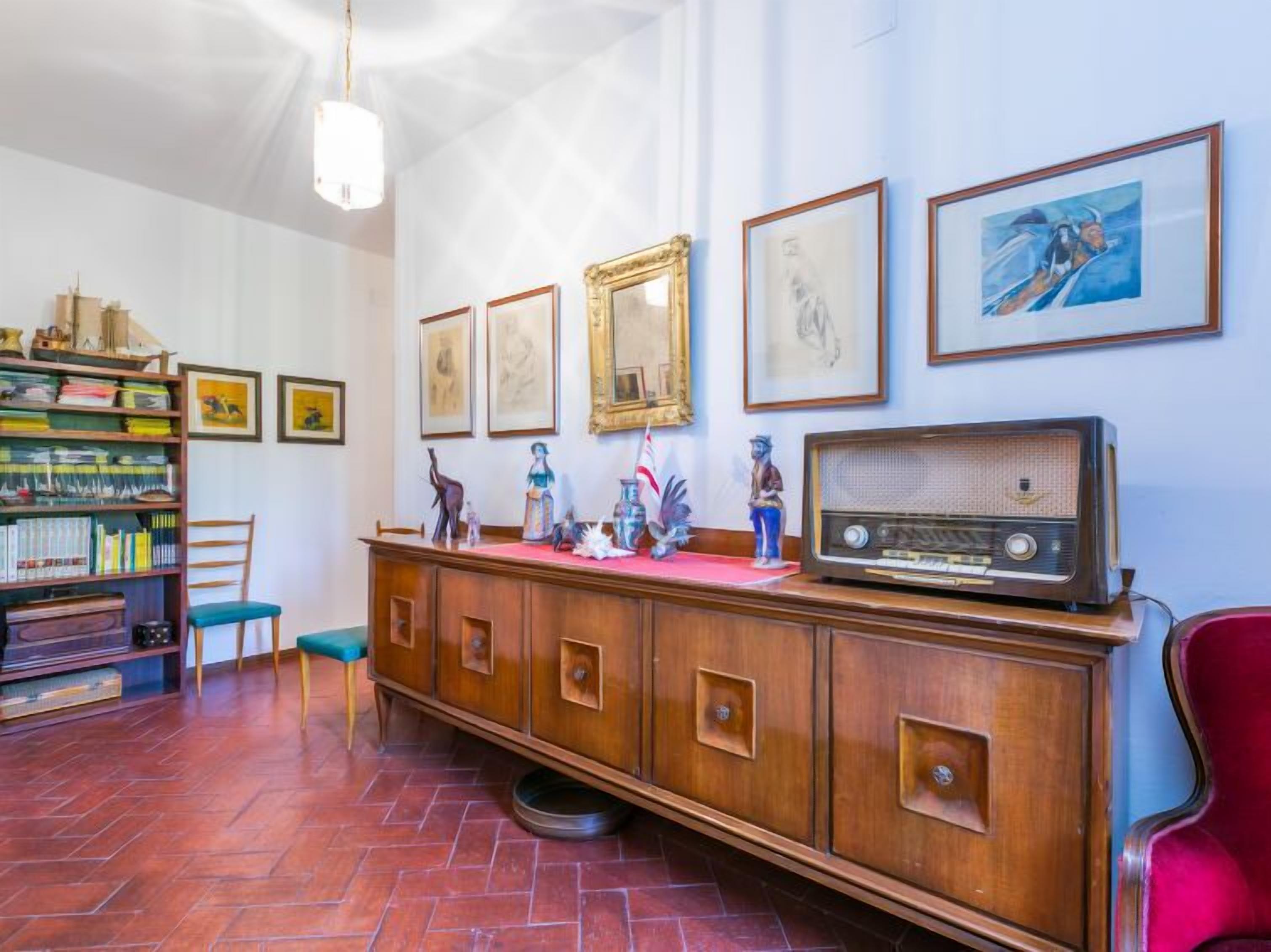 Een kamer met een houten kast, boekenplanken en lijstwerken aan de muren.