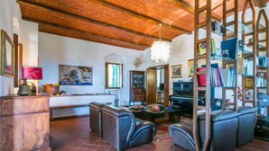 A spacious living room with a brick ceiling, leather sofas, a piano, and a bookshelf. - I Cancelli by Interhome (Florence)