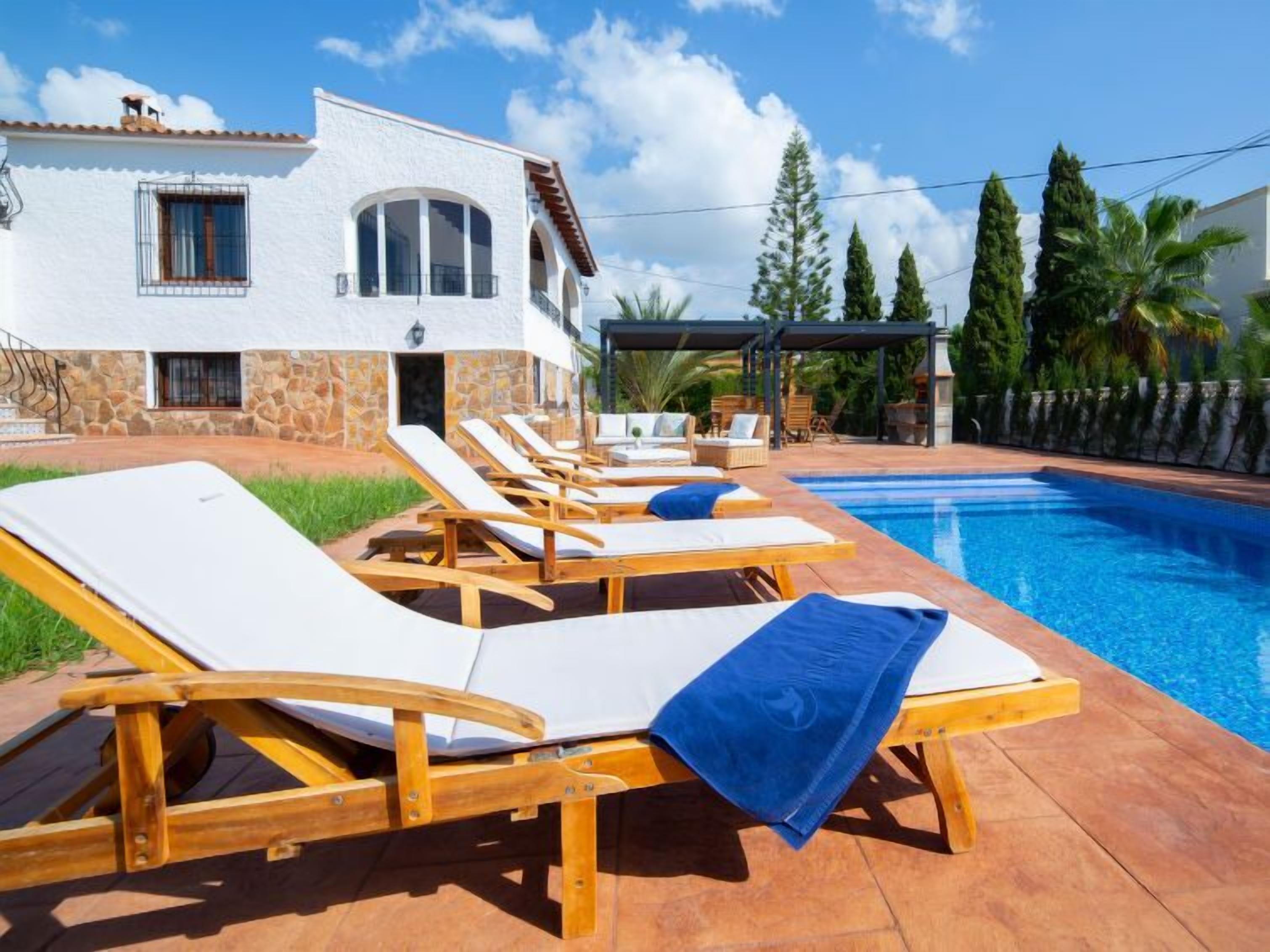 A poolside area with lounge chairs and a swimming pool.