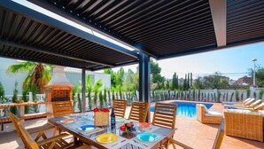 An outdoor dining area with a pool and lounge chairs. - Vacation home Agave by Interhome (Calpe/Calp)