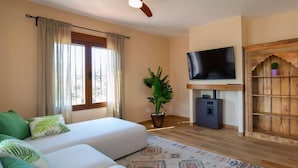 A room with a sofa, a television, a plant, and a wooden cabinet. - Vacation home Agave by Interhome (Calpe/Calp)