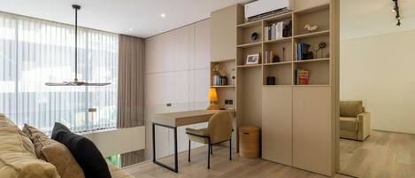 A modern living room with a sofa, a desk, and a bookshelf.