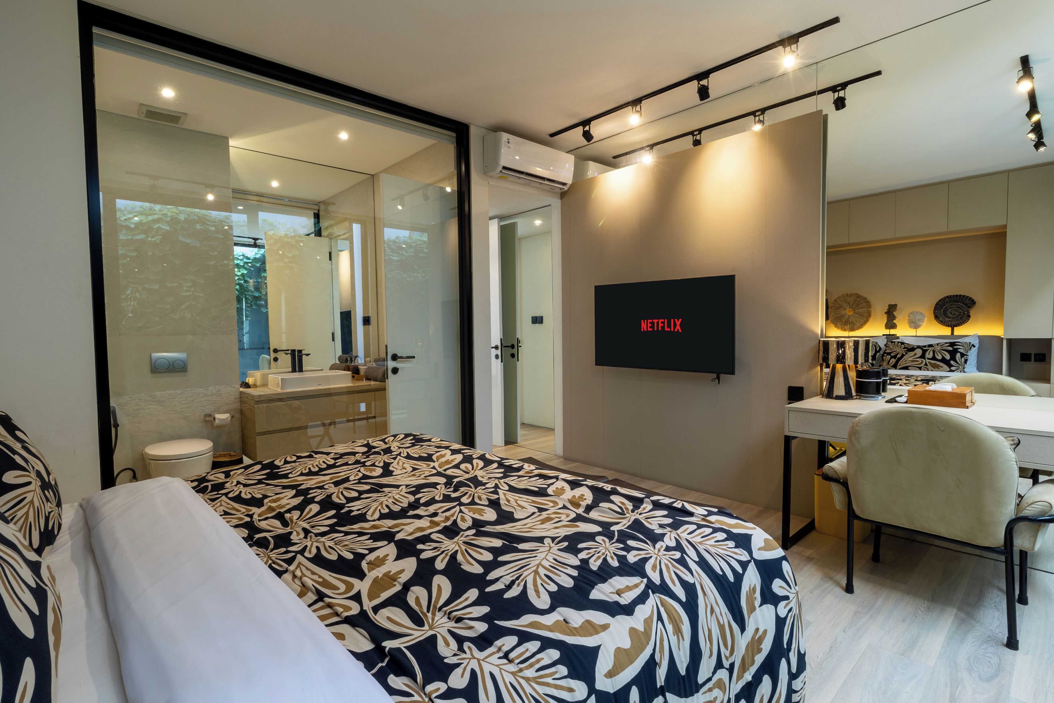 Een moderne hotelkamer met een groot bed, een bureau, een stoel, een televisie en een badkamer.
