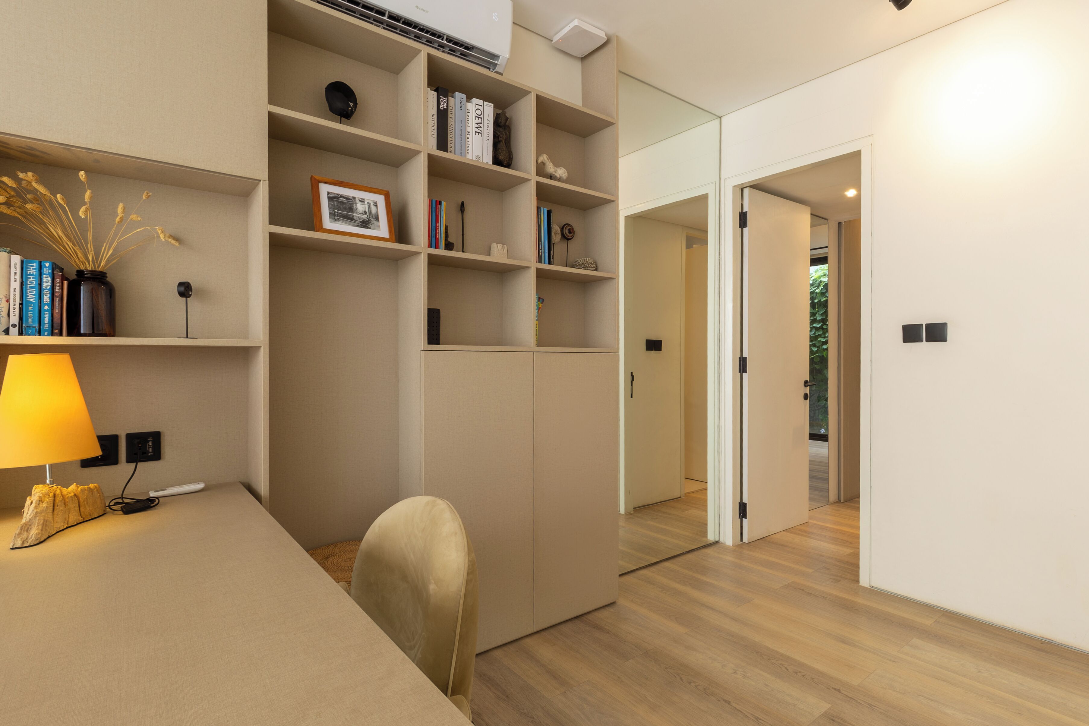 A modern room with a desk, bookshelves, and a wardrobe.