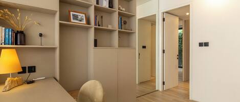 A modern room with a desk, bookshelves, and a wardrobe.