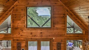 Una cabaña de madera con un amplio ventanal que da a un bosque.