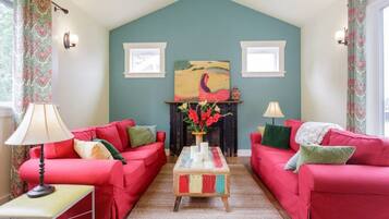 A living room with two red sofas, a wooden coffee table, and a fireplace.
