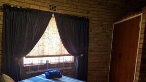 A room with a bed, curtains, a window, and a door. - Klein Huisie Little House Self Catering Africa Bush Vacation In Marloth Park (Nkomazi)