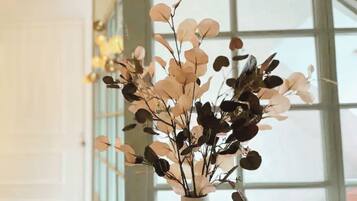 A vase with a floral arrangement in a room with large windows.