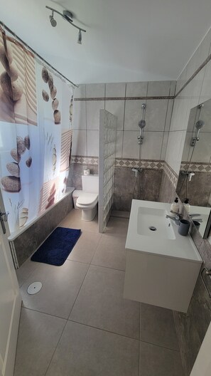 Regadera, secadora de cabello, toallas, papel de baño 
