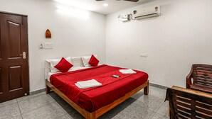 Un dormitorio con cama, ventilador de techo, aire acondicionado y puerta de madera.