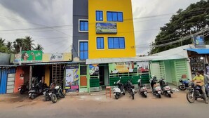 Un edificio de varios pisos con fachada amarilla y gris, varias ventanas y un letrero del French Park Inn.