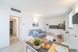 Un appartamento moderno con zona pranzo, cucina e soggiorno.