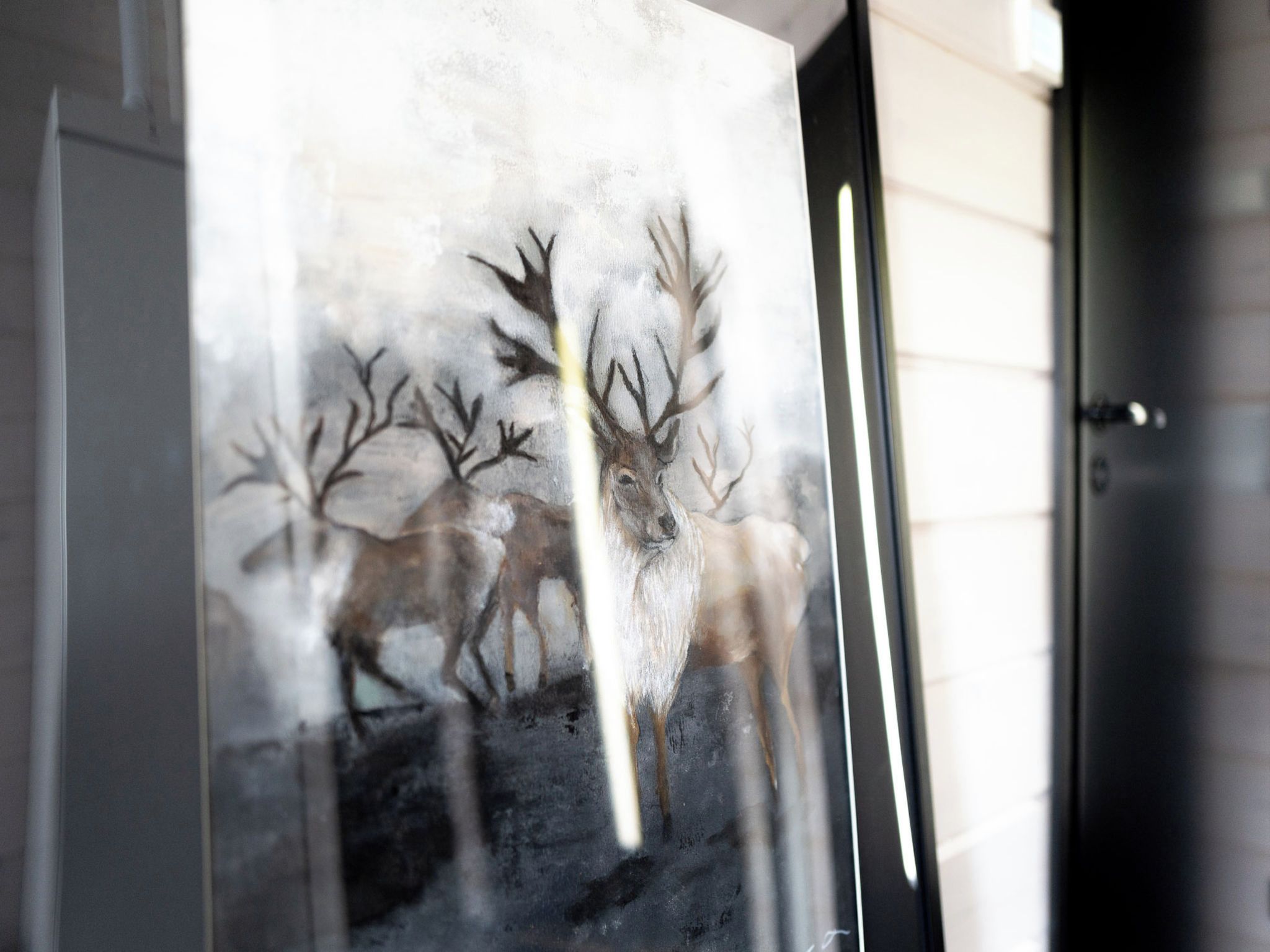 A glass door with a frosted glass panel featuring a deer silhouette.