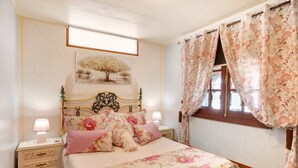 A bedroom with a bed, nightstands, a window with curtains, and a wall-mounted picture. - Vacation Home 'Los Diablitos 5' with Mountain View, Shared Terrace and Wi-Fi (Santa Cruz de Tenerife)