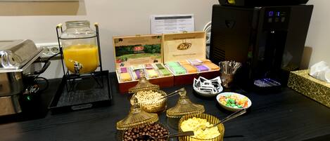 Disposición de bufé con diversos alimentos y una máquina de café.