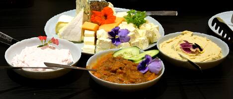 A table with various food items including cheese, vegetables, and dips.