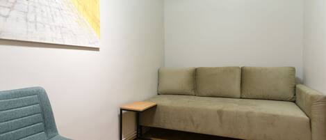 A room with a sofa, a chair, and a small table.