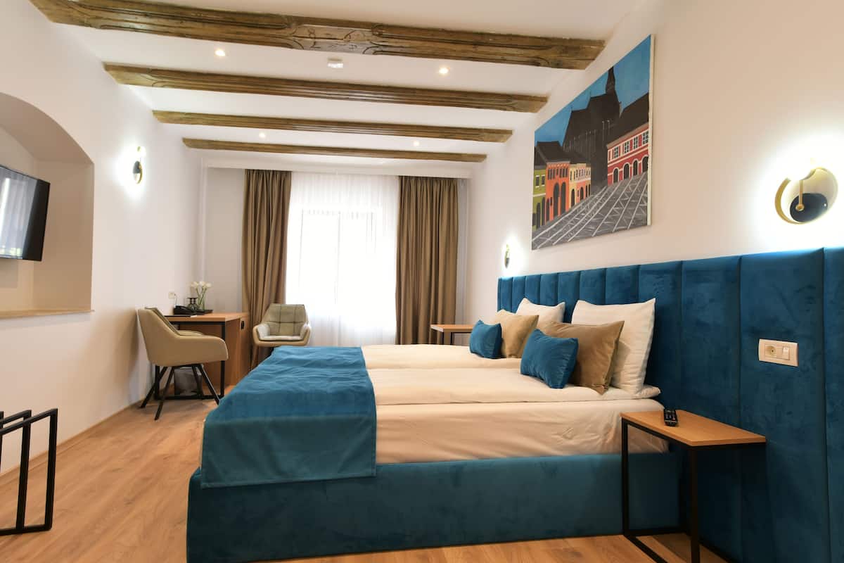 Une chambre d’hôtel avec un grand lit, un bureau et une chaise.