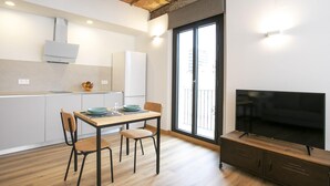 Un espacio habitable compacto con cocina, comedor y televisor.