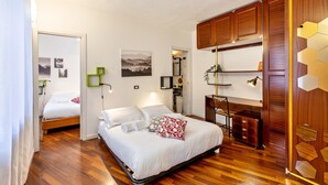 Une chambre à coucher avec un lit, une armoire en bois et un bureau avec une chaise.