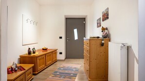 Een gang met houten kasten, een radiator en een deur.