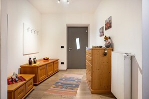 Un couloir avec des armoires en bois, un radiateur et une porte.