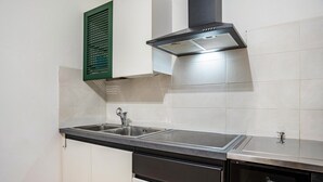 Een keuken met een dubbele spoelbak, een vaatwasser, een kookplaat en een afzuigkap.