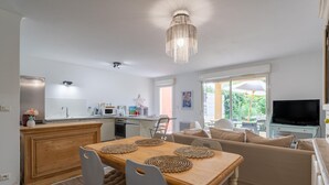 Una cocina moderna con comedor, sofá y televisor.