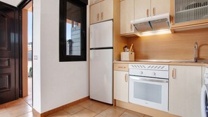 Une cuisine équipée d’un réfrigérateur, d’un four et d’un lave-linge.