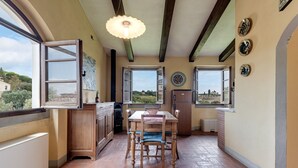 Una cocina con una mesa de comedor, armarios de madera y vistas a través de las ventanas.