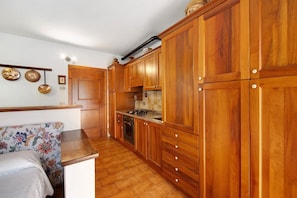 A kitchen with wooden cabinets, a countertop, and a stove.