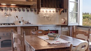 A kitchen with wooden cabinets, a gas stove, and a window with a view of greenery. - Farmhouse 'Il Pintello - Il Riccio' with Shared Pool, Wi-Fi and Air Conditioning (San Casciano VP)