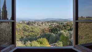 A view through a window of a town surrounded by hills and trees. - Farmhouse 'Il Pintello - Il Riccio' with Shared Pool, Wi-Fi and Air Conditioning (San Casciano VP)