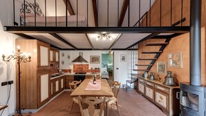 A spacious kitchen with wooden cabinets, a dining table, and a built-in stove. - Farmhouse 'Il Pintello - Lo Scricciolo' with Shared Pool, Wi-Fi and Air Conditioning (San Casciano VP)