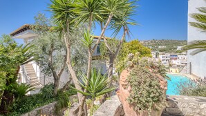 Una zona residenziale con piscina, una scala e diverse piante.