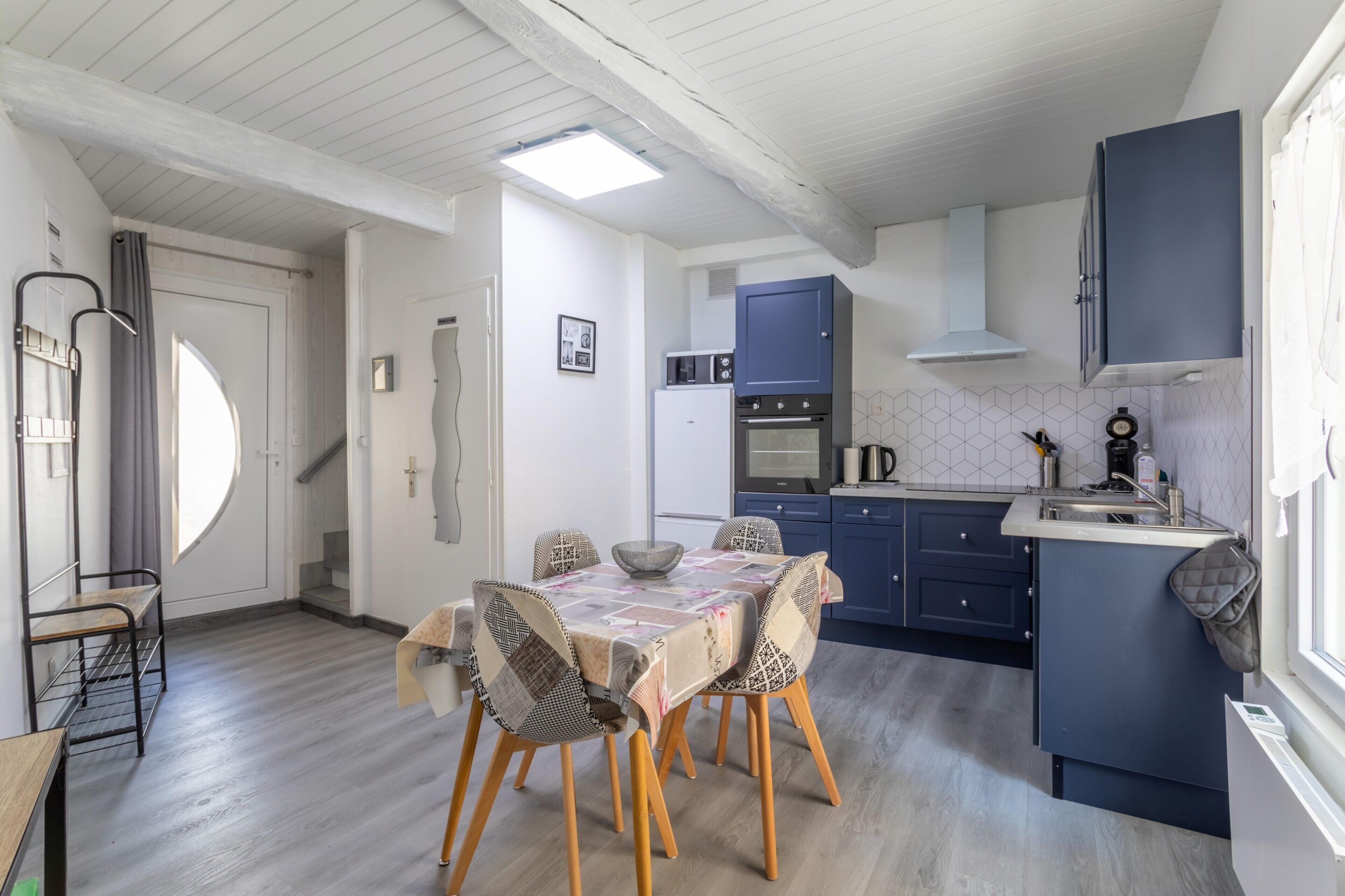 Una cocina compacta con una mesa de comedor, sillas y un horno empotrado.