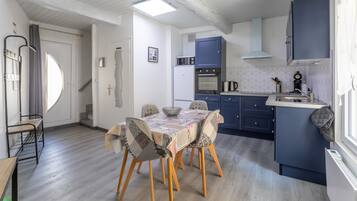 Una cocina compacta con una mesa de comedor, sillas y un horno empotrado.