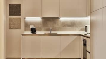A modern kitchen with a stainless steel sink, a built-in oven, and a coffee maker.