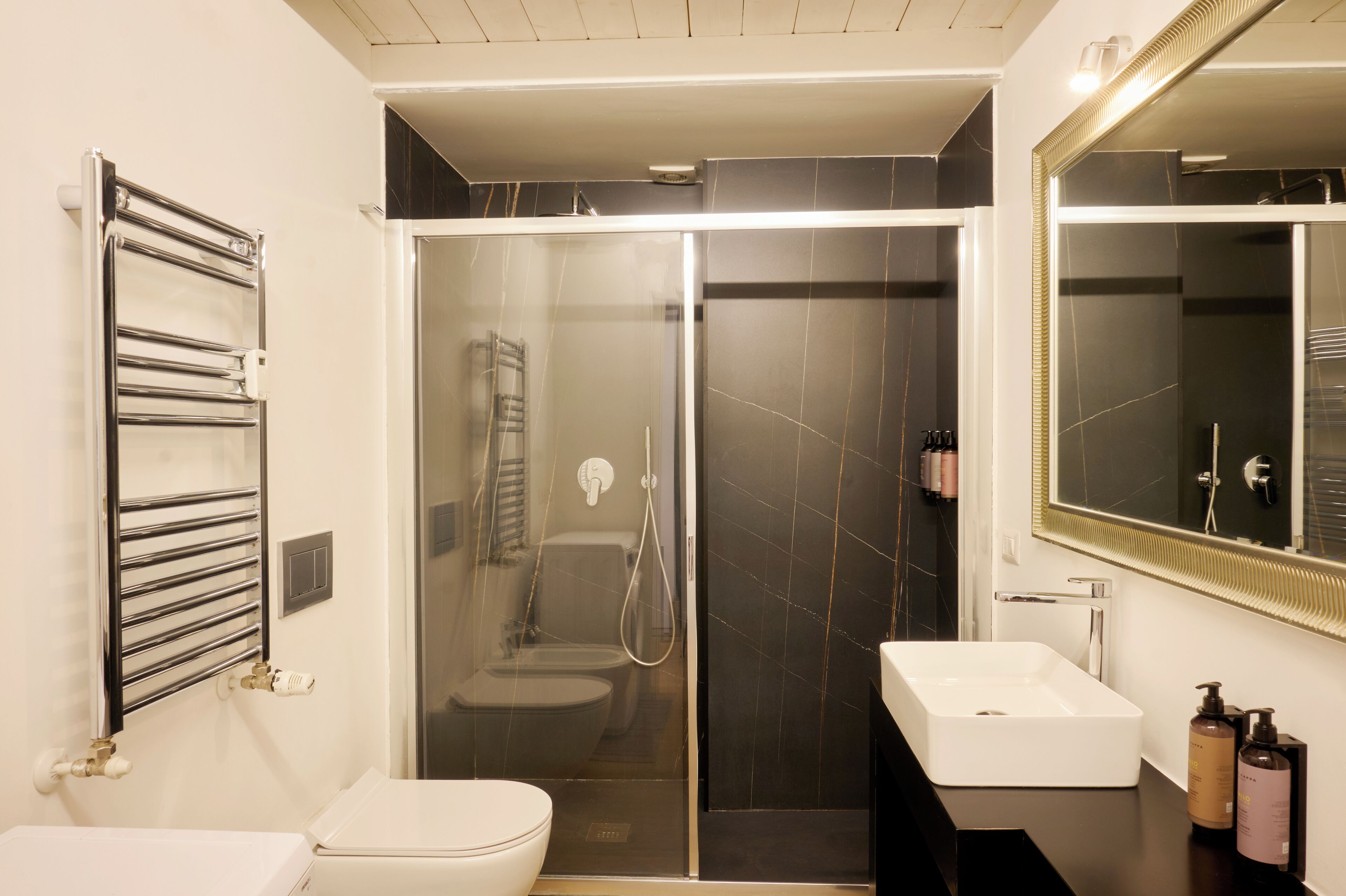 Une salle de bain moderne avec une douche à parois de verre, un lavabo blanc et un porte-serviettes.
