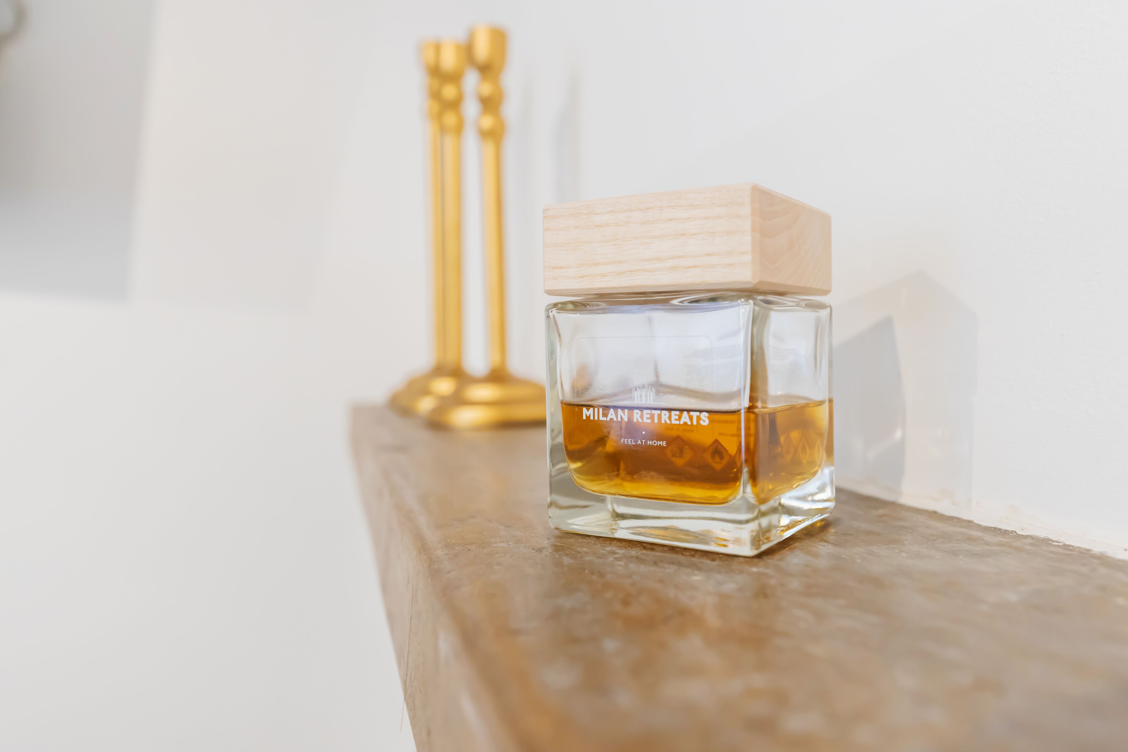 A bottle of Milan Retreats cologne on a wooden surface.