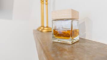 Une bouteille de parfum Milan Retreats posée sur une surface en bois.