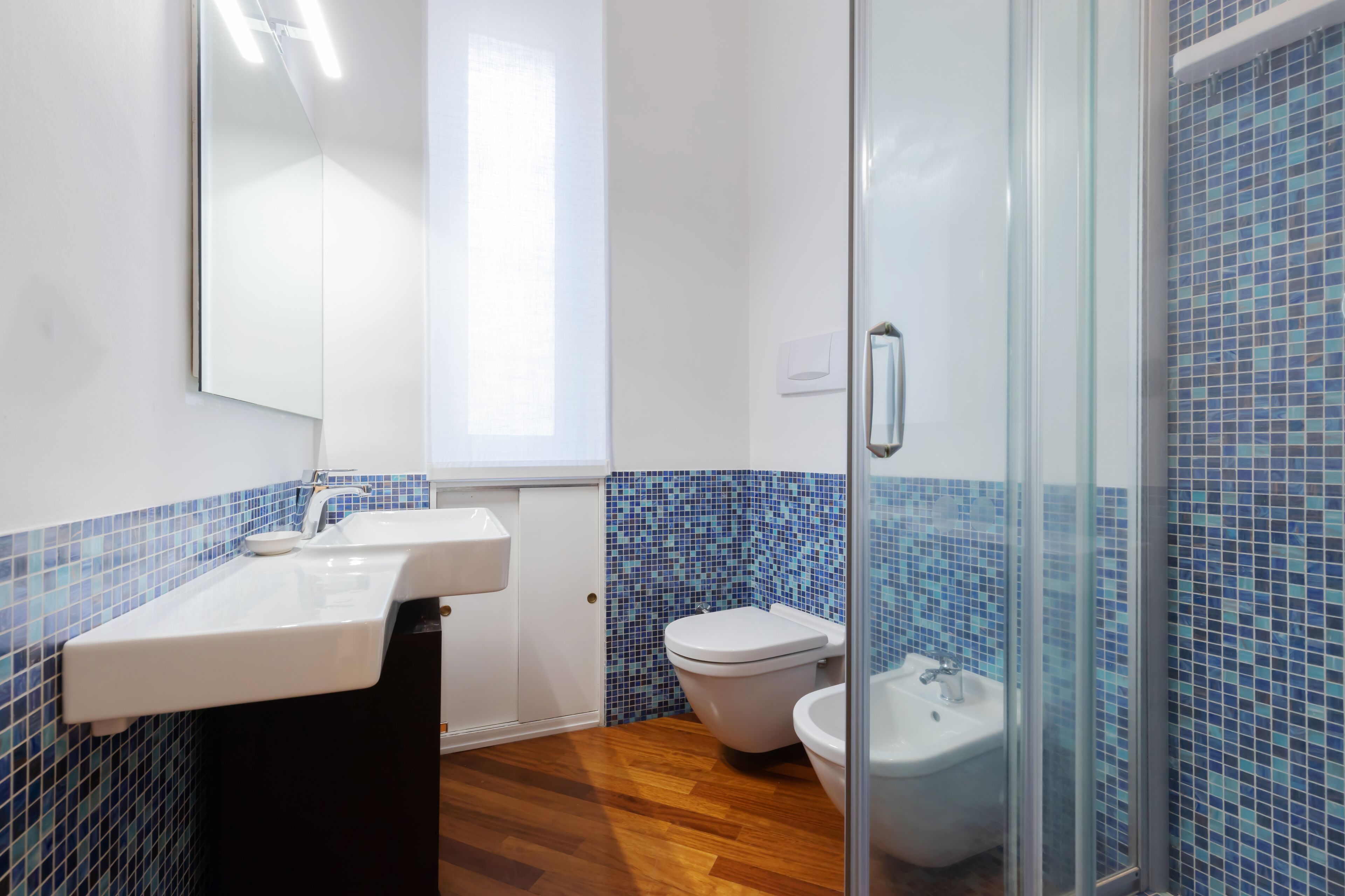 Une salle de bain avec un lavabo blanc, des toilettes et un bidet.