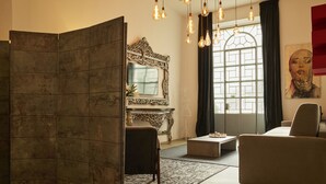 A modern living room with a sectional sofa, a coffee table, a decorative mirror, and a fireplace. - Milan Retreats Brera (Milan)