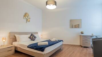 Una camera da letto moderna con un letto in legno, lampade da comodino, una scrivania e una sedia.