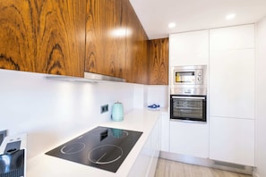 A modern kitchen with wooden cabinets, a built-in oven, and a stovetop.