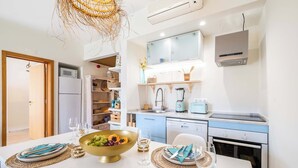 A modern kitchen with a central island, built-in appliances, and a hanging light fixture.